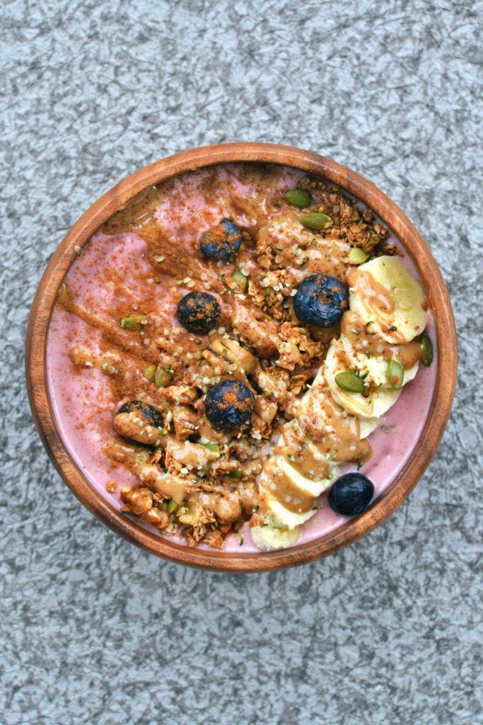 vegan peanut butter and jelly smoothie bowl with granola banana berries