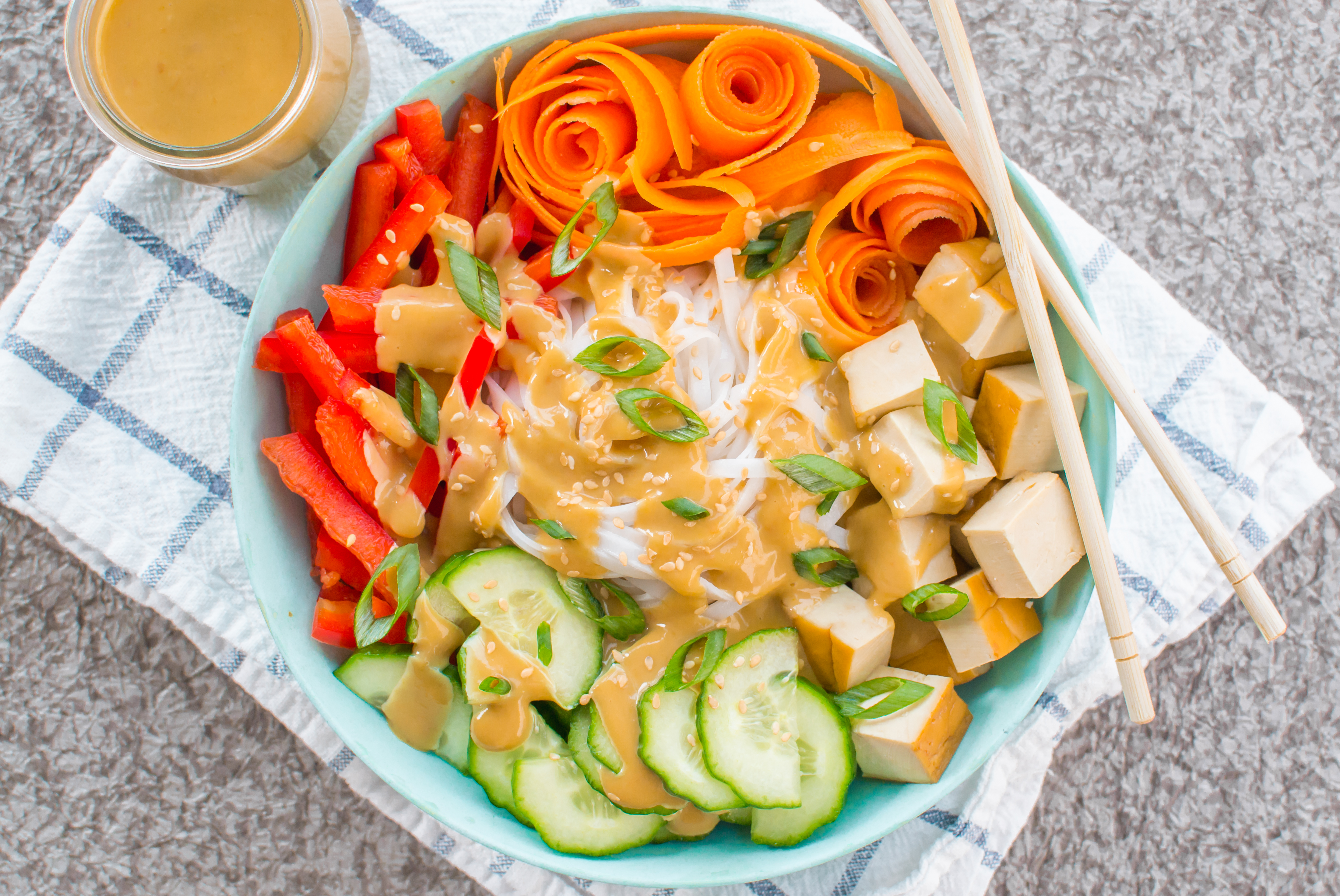 summer rice noodle bowl with assorted vegetables miso ginger tahini dressing