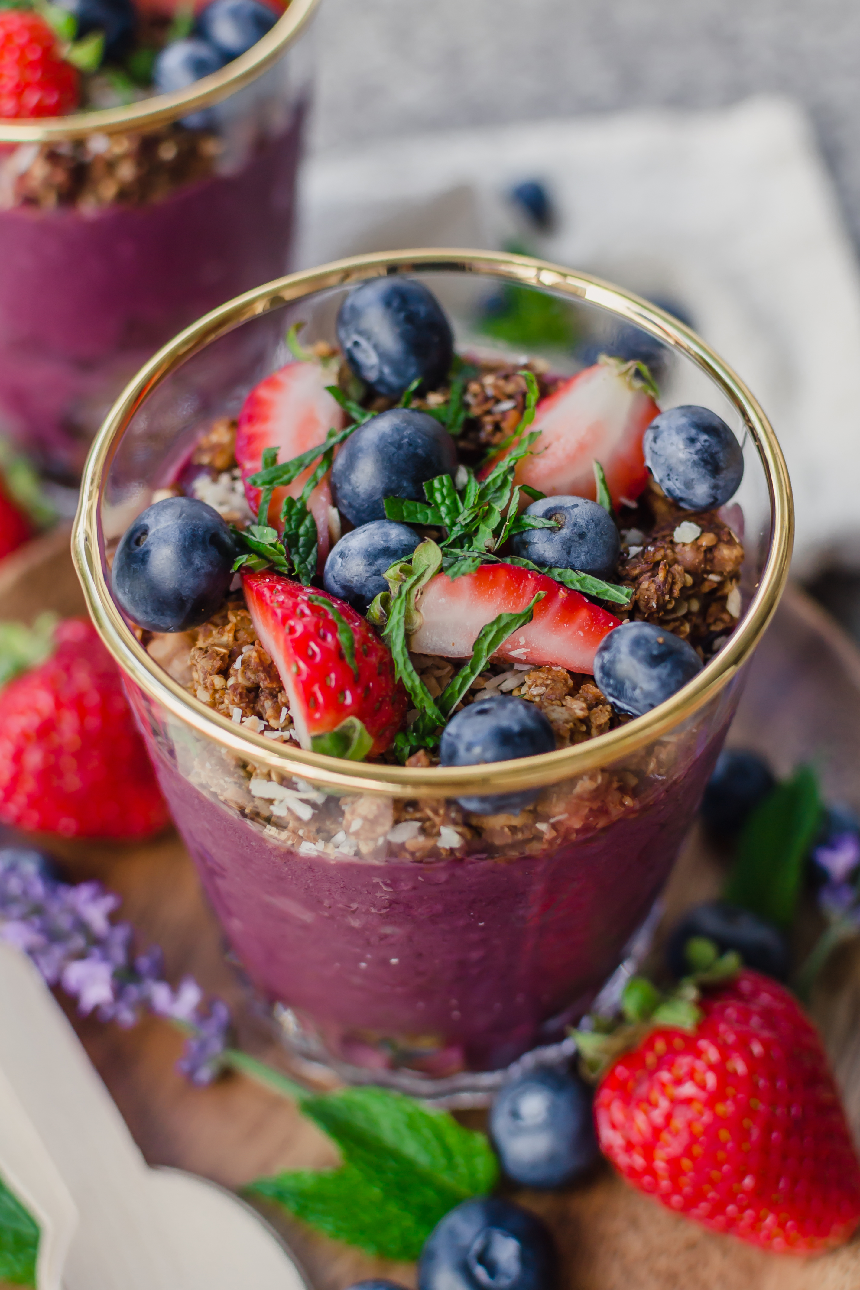 acai parfaits in a cup with berries and mint